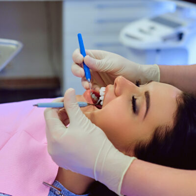 Dentist examining female's teeth in dentistry. Close-up image of a dentist examining female's teeth in dentistry.