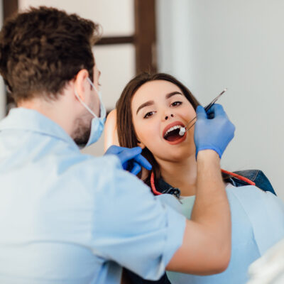 dentist-making-professional-teeth-cleaning-withb-cotton-female-young-patient-dental-office Dentist making professional teeth cleaning withb the cotton, female young patient at the dental office.